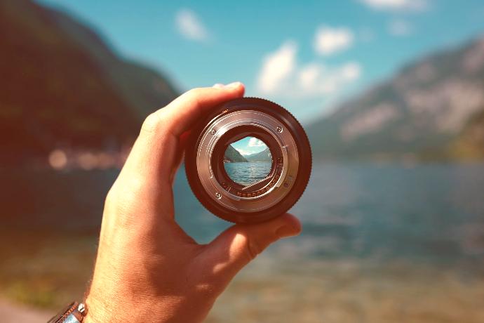 person holding camera lens